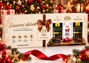 Fine Gusto Jerky Advent Calendar, cream and gold box with copper bow and Biltong, Fine Gusto and Droëwors packs, under a Christmas tree