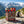 Beef & Beyond Box with Jack Link's and Renjer on a rock beside a mountain trail in the Alps, with a backpack and thermos, AI-generated image