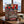 Beef & Beyond Box with Jack Link's and Renjer on a wooden table in a mountain chalet, with a wool blanket, an enamel mug and snowy mountains outside, AI-generated image