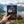 Hand holding Meat Makers Beef Original Smoky in front of a fjord landscape, AI-generated image