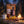 BeJerky Boar Jerky Original on a log by a campfire in a pine forest at dusk, with an enamel mug, AI-generated image