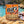 BiFi Chicken High Protein 5-pack on a rock by a Mediterranean cove, with a towel and sunglasses, AI-generated image