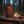 Biltong Premium Biltong Piri Piri on a log by a campfire in a pine forest at dusk, with an enamel mug and a wooden cup, AI-generated image