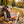 Chokay Bar Dark Almond Sea Salt sticking out of a backpack on a park bench in autumn, with a water bottle and headphones, AI-generated image