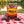 Cruga Biltong Chilli on a checked picnic blanket by a lake on a summer day, with a steel cup and sunglasses, AI-generated image