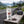 Fine Gusto Beef Jerky Natural on a bench by a gravel road, with a bike and a cycling helmet, AI-generated image