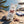 Fine Gusto Beef Jerky Natural on a smooth coastal rock by the sea, with a towel and sunglasses, AI-generated image
