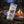 Fine Gusto Beef Jerky Pepper on a log by a campfire in a pine forest at dusk, with an enamel mug and a wooden cup, AI-generated image