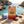 Grizzly Foods Vegan Jerky Burn Baby Burn on a rock by a Mediterranean cove, with a towel and sunglasses, AI-generated image