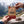 Hand holding Grizzly Foods Vegan Jerky Burn Baby Burn in front of an alpine mountain landscape, AI-generated image