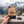 Hand holding Grizzly Foods Vegan Jerky Cracked Pepper in front of an alpine mountain landscape, AI-generated image