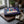 Happy Birthday Box on a dark wooden cutting board on a kitchen counter in soft window light, AI-generated image