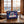 Happy Birthday Box on a wooden table in a mountain chalet, with a wool blanket, an enamel mug and snowy mountains outside, AI-generated image