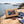Indiana Cut Your Own Biltong Box on a smooth coastal rock by the sea, with a towel and sunglasses, AI-generated image