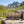 KJØ Mixed Pack on a rock beside a mountain trail in the Alps, with a backpack and thermos, AI-generated image