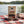 KJØ Goddamn Spicy Beef Jerky on a checked picnic blanket by a lake on a summer day, with a steel cup and sunglasses, AI-generated image