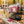 KoRo Freeze-Dried Raspberries sticking out of a backpack on a park bench in autumn, with a water bottle and headphones, AI-generated image