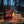 Leon Jerky Beef Original on a log by a campfire in a pine forest at dusk, with an enamel mug, AI-generated image