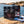 Meat Makers Beef Steak Mix on a smooth coastal rock by the sea, with a towel and sunglasses, AI-generated image