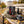 Meat Makers Smoky Beef Bites sticking out of a backpack on a park bench in autumn, with a water bottle and headphones, AI-generated image