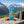 Mr. Beast Feastables Almond on a rock beside a mountain trail in the Alps, with a backpack and thermos, AI-generated image