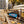 Mr. Beast Feastables Milk Crunch sticking out of a backpack on a park bench in autumn, with a water bottle and headphones, AI-generated image