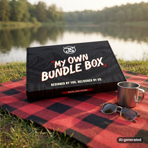 My Own Bundle Box on a checked picnic blanket by a lake on a summer day, with a steel cup and sunglasses, AI-generated image