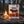 QINA Beef Sliced Biltong on a log by a campfire in a pine forest at dusk, with an enamel mug, AI-generated image