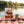 QINA Beef Sliced Biltong on a checked picnic blanket by a lake on a summer day, with a steel cup and sunglasses, AI-generated image