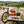 QINA Beef Sliced Biltong on a bench by a gravel road through vineyards, with a bike and a cycling helmet, AI-generated image