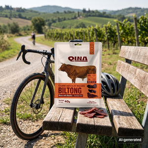 QINA Beef Sliced Biltong on a bench by a gravel road through vineyards, with a bike and a cycling helmet, AI-generated image