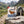 QINA Eland Snapstick Biltong Chilli on a rock beside a mountain trail in the Alps, with a backpack and thermos, AI-generated image