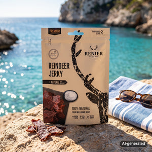 Renjer Reindeer Jerky Sea Salt on a rock by a Mediterranean cove, with a towel and sunglasses, AI-generated image